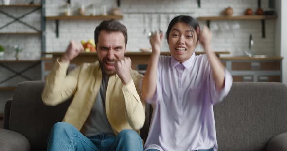 Excited Multiracial Couple Looking at Camera Feel Winners Surprised By Lottery Betting Winning Bid