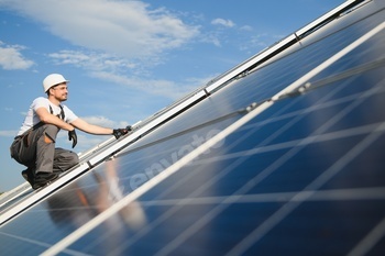 Man technician mounting photovoltaic solar moduls.