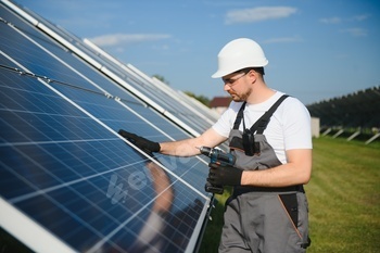 Man technician mounting photovoltaic solar moduls.