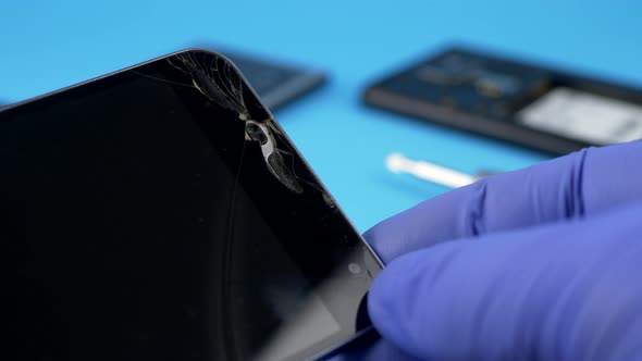 Technician Worker Holding Scratched Black Smartphone