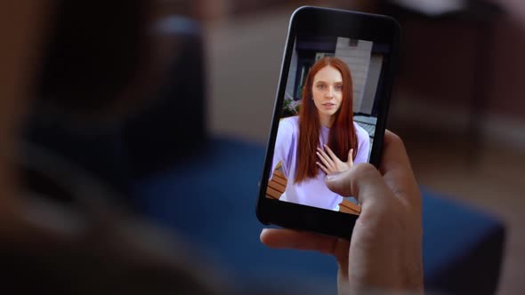 Closeup of Man Having Video Chat Via Mobile Phone Enjoying Conversation to Redhead Girlfriend From