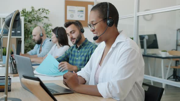 Multiethnic Group of People Chatting Working in Call Center Using Computers and Headsets