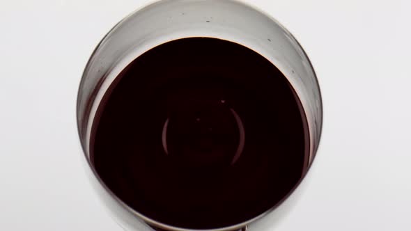 Red Wine Droplet Falling Rippling in Goblet Closeup