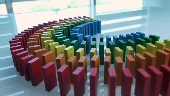 Line up of Dominoes in Rainbow Falling Colors with LGBT Colors of a Hand