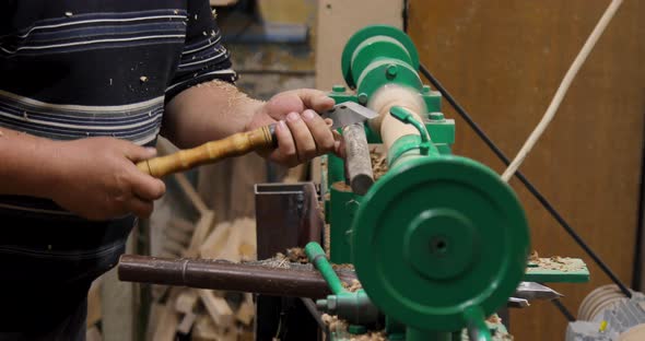 Side view of carpenter turning wood on a lathe