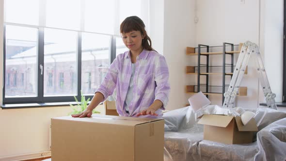 Woman with Adhesive Tape Packing Box at New Home