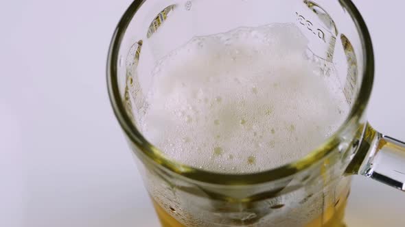 Pouring Beer Into A Glass Top View On A White Background, Draft Beer Foamy.