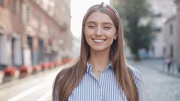 Portrait of Young Happy Charming Girl with Straight Brown Hair and Blue Eyes Wearing in Striped