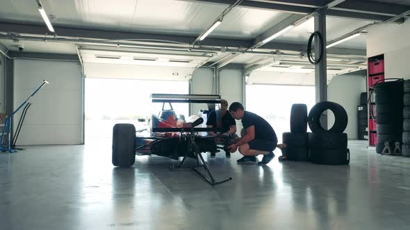 Maintenance Specialists are Inspecting the Frame of the Racing Car