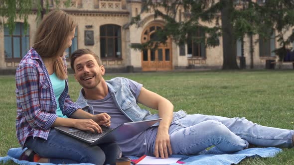 Couple of Students Exercises on the Lawn on Campus