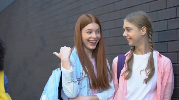 Two Caucasian Teenagers Laughing at Female Afro-American Classmate, Condemnation