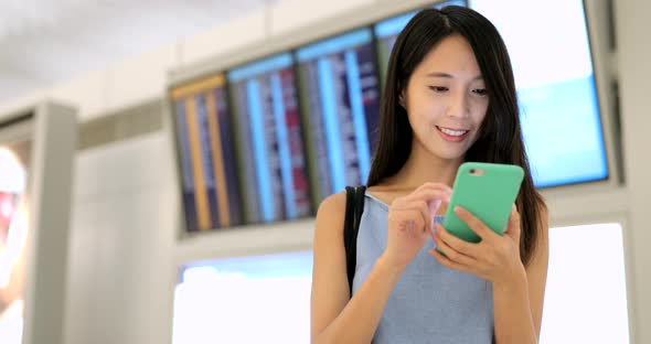 Woman looking at cellphone in airport 