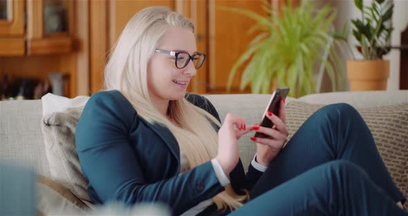 Businesswoman Using Mobile Phone On Sofa