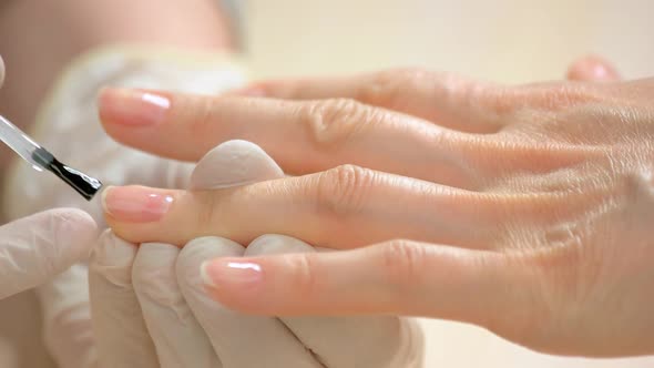 Woman Receiving Manicure in Beauty Salon.