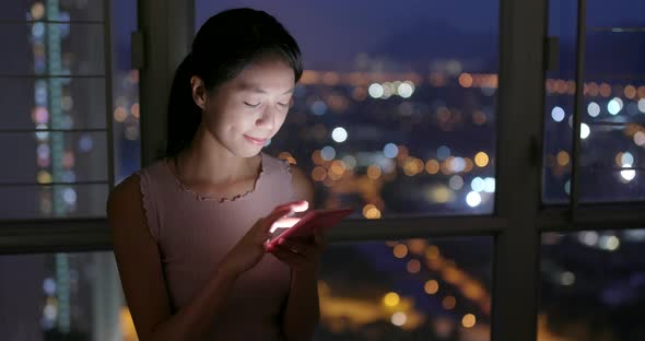 Woman working on cellphone at night 