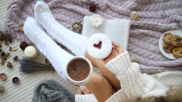 Woman In Knitted Socks Drinking Hot Chocolate With Cookies At Home