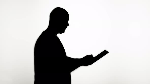 Shadow of Man Reading Book Closeup Silhouette of Male Person Reads Story on White Background