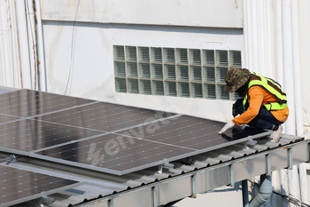 Technicians Install photovoltaic solar modules on roof of house.