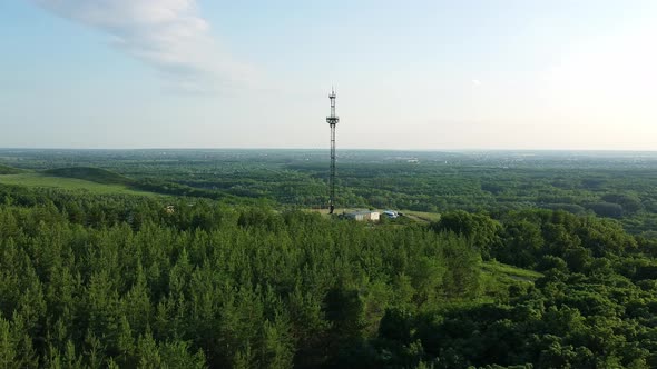 Aerial view of the flight by drone over the trees and next to the antenna. 5g communications tower 