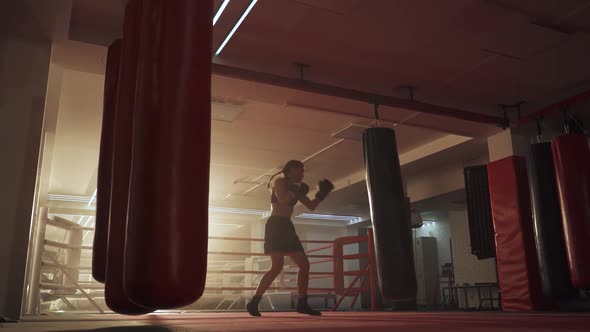 Female Fighter Trains His Punches, Beats a Punching Bag, Training Day in the Boxing Gym