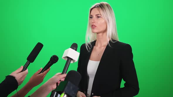 Caucasian Female Gives an Interview to Journalists Communication with the Press Microphones in the
