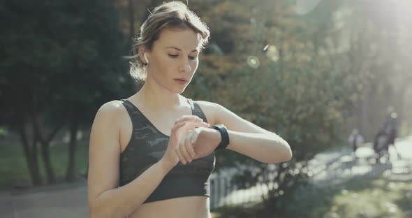 Fitness Woman In Airpods Using Smartwatch