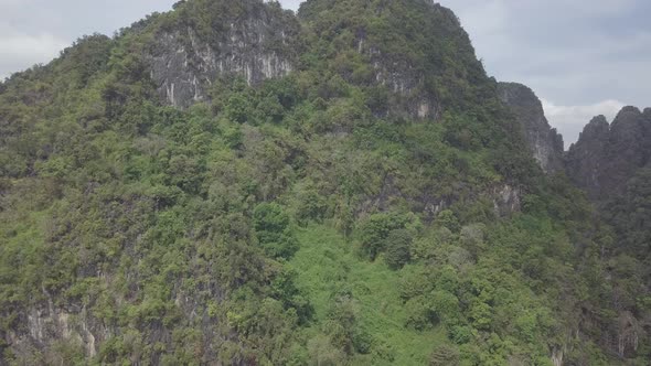 Aerial footage of Buddha on top of Tiger Cave Temple, Wat Thum Sua, stone rocks, Krabi, Thailand.