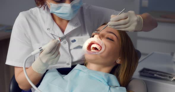 Dentist Performs Professional Teeth Cleaning for a Beautiful Female Patient