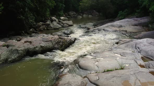 Flight over small waterfall in a rocky river, jungle of Koh Samui, Thailand