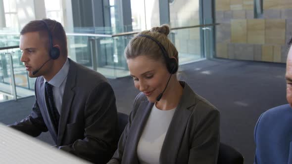 Young business people wearing headsets in a modern office