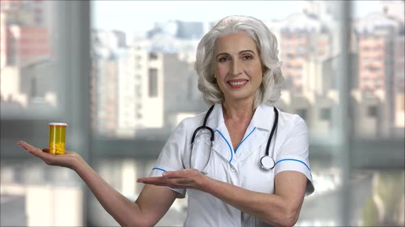 Senior Doctor Lady Shows Bottle of Pills