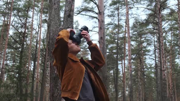 Low Angle View of Man on Hiking Trip Taking Photos in Forest with Digital Camera