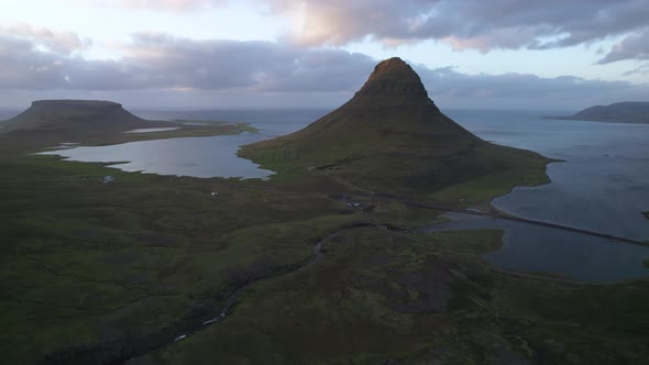 Green mountain peak near sea at sunset