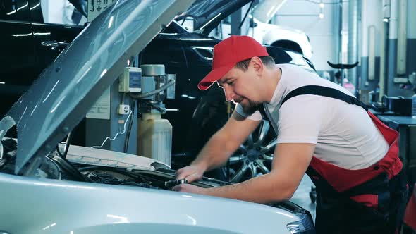 Car Repair Master Uses a Wrench to Fix an Automobile