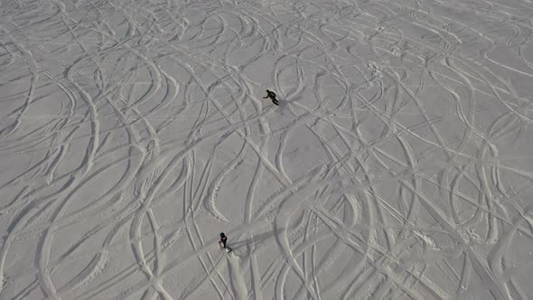 Snowboarders Ride on Top of a Mountain