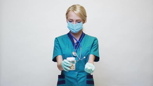 Medical Doctor Nurse Woman Wearing Protective Mask and Rubber or Latex Gloves - Holding Pills