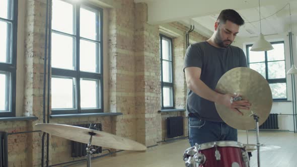 Man Setting Up Drum Kit before Playing