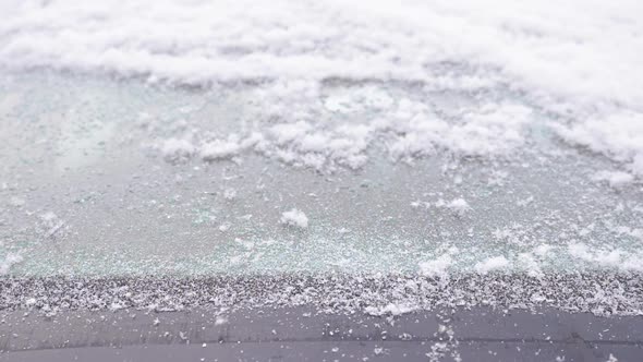 Windshield Wipers Brushing Away Snow From a Car's Windshield in Slow Motion