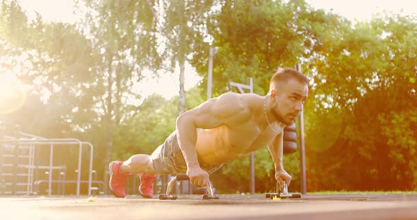 Strong Man Doing Push Ups at Sports Ground in City Park