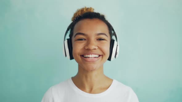 Close-up Slow Motion Portrait of Happy African American Girl in Headphones Looking at Camera