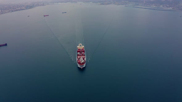Aerial View of Ship with Numerous Containers Sailing the Ocean