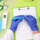 doctor in a white coat and with other latex gloves holds a blue pen - VideoHive Item for Sale