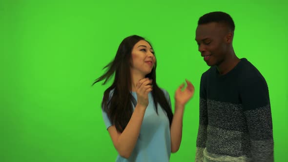 A Young Asian Woman and a Young Black Man Celebrate - Green Screen Studio