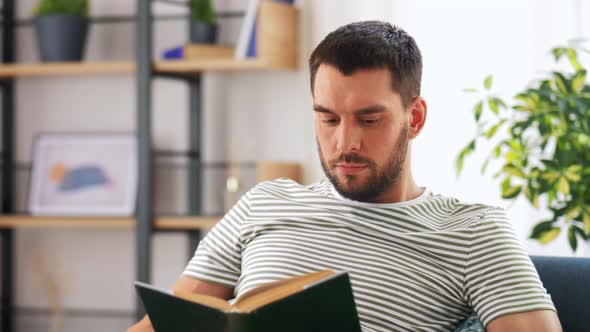 Portrait of Happy Smiling Man Reading Book at Home