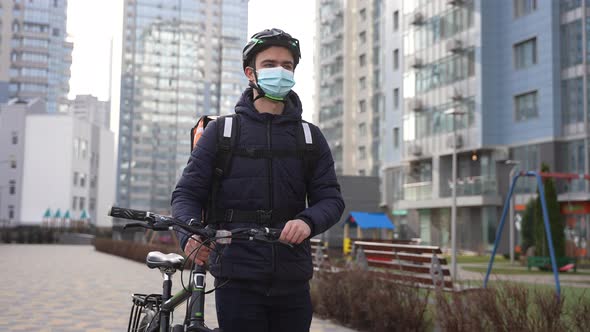 Masked Delivery Food Courier Walking Carrying Bike