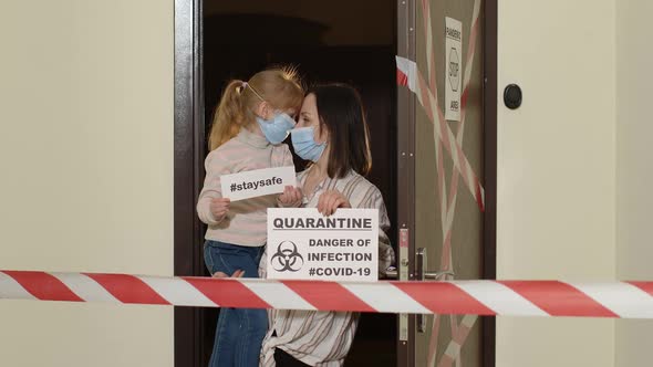 Sick Mother with Kid Daughter in Medical Masks Opening Home Door Coronavirus Quarantine Lockdown