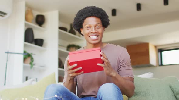 African american man opening gift at home