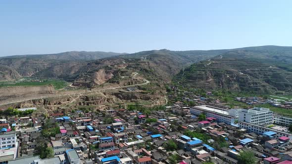 Aerial View of Small Poor Town Next the Arid Terraced Farm Firld Mountain