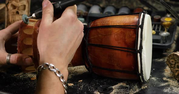 Close up male hands using power wood working tools graver, carving