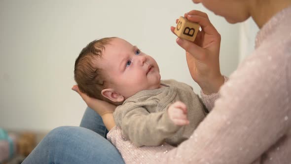 Mommy Showing Cute Yawning Child Different Toys, Infant Early Development